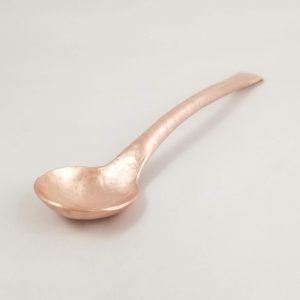 A formed copper spoon
