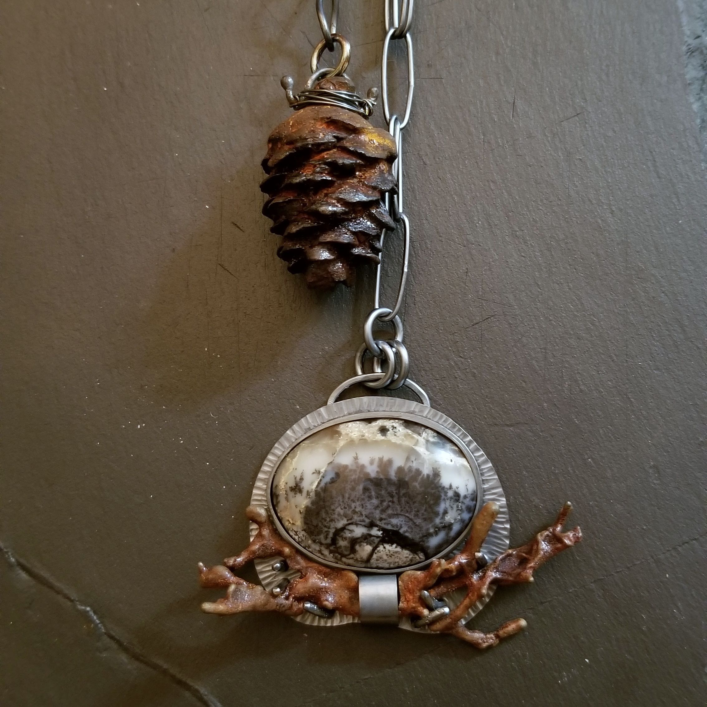 an image of the cast iron spruce cone and the dendritic agage pendant and cast iron lichen set at each end of the lariat