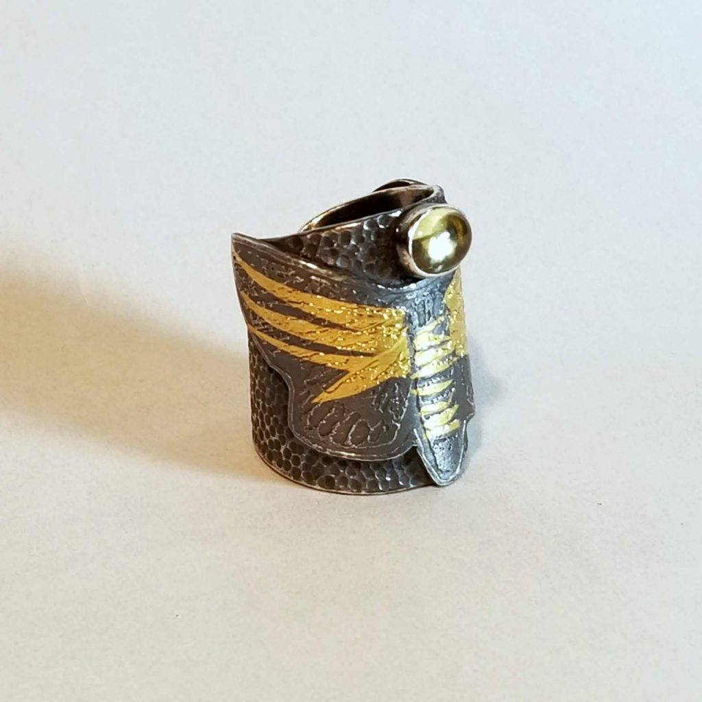 A textured silver ring, etched with a moth, and accented with keum bo gold. Set with a citrine cabochon.