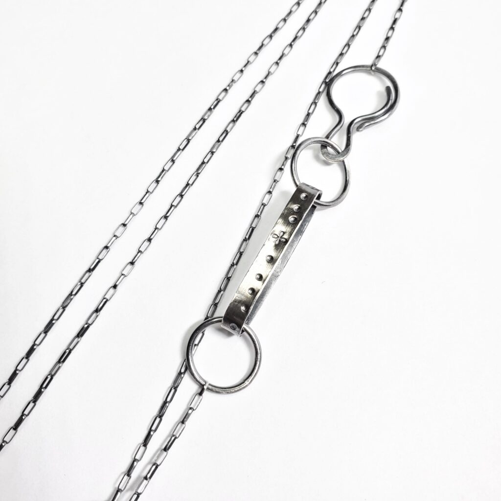 The clasp and catch of the elongated terrain pendant.