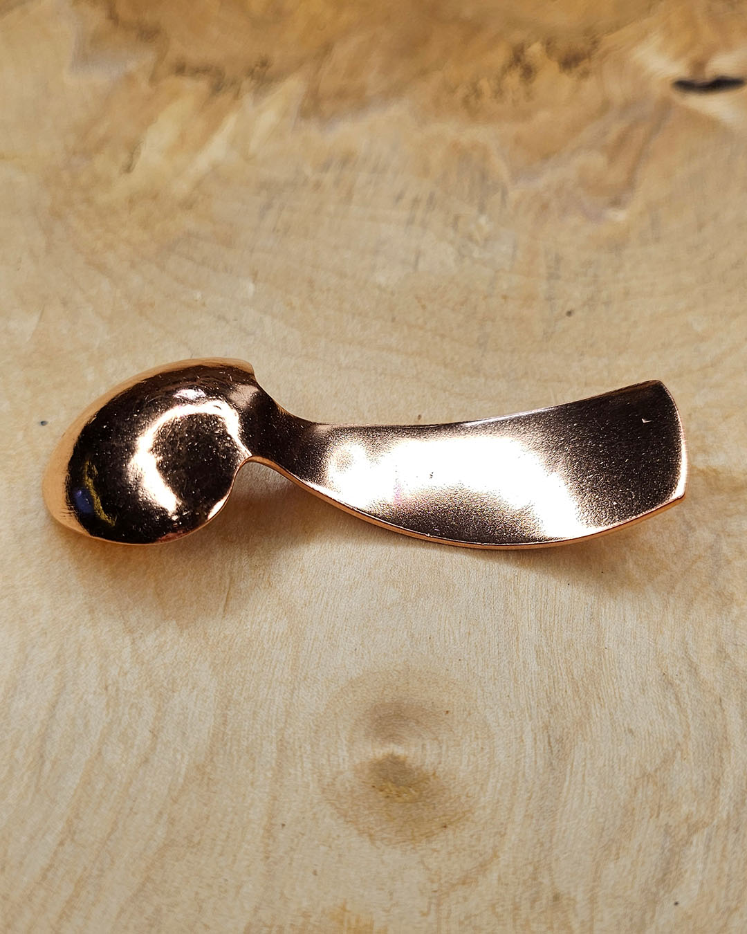 A small copper spoon stamped with three traditional eight-pointed stars
