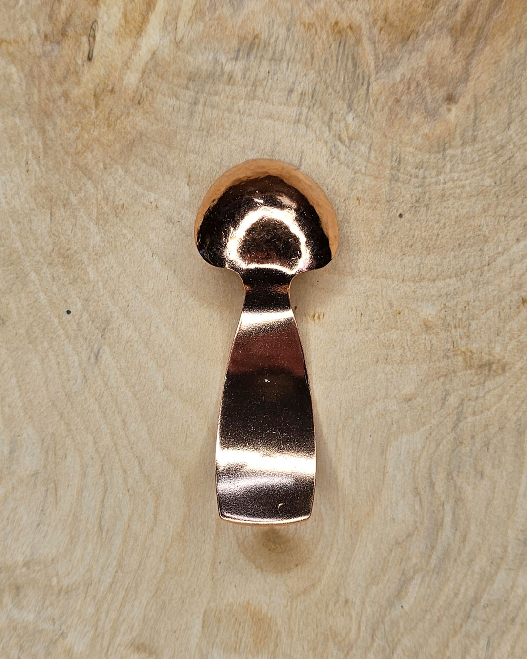 A small copper spoon stamped with three traditional eight-pointed stars