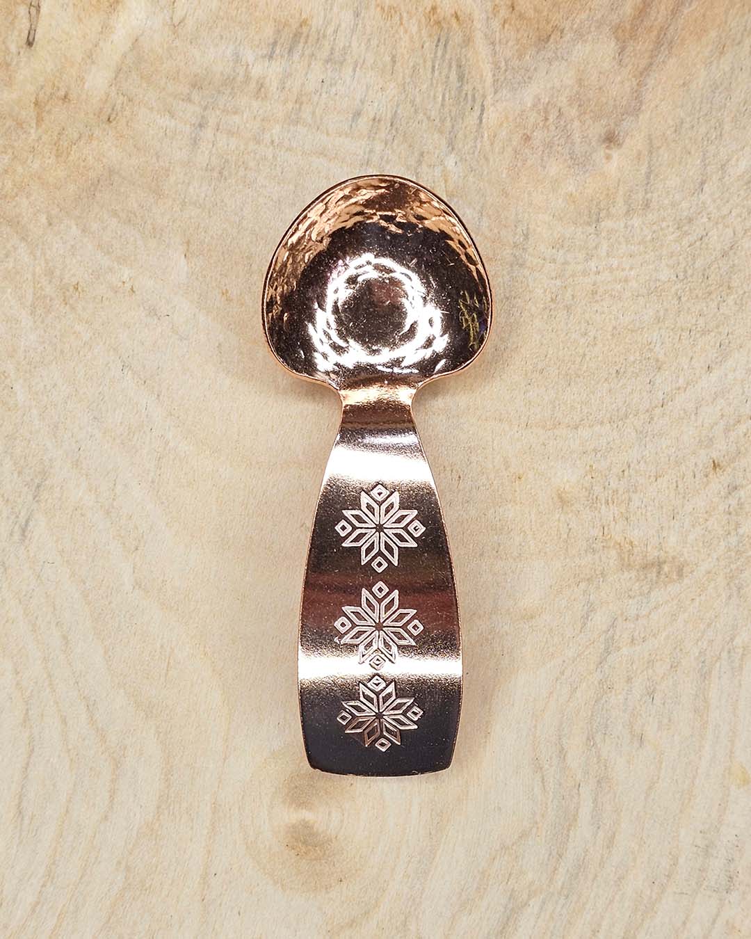 A small copper spoon stamped with three traditional eight-pointed stars