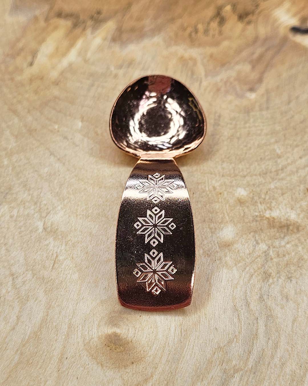 A small copper spoon stamped with three traditional eight-pointed stars
