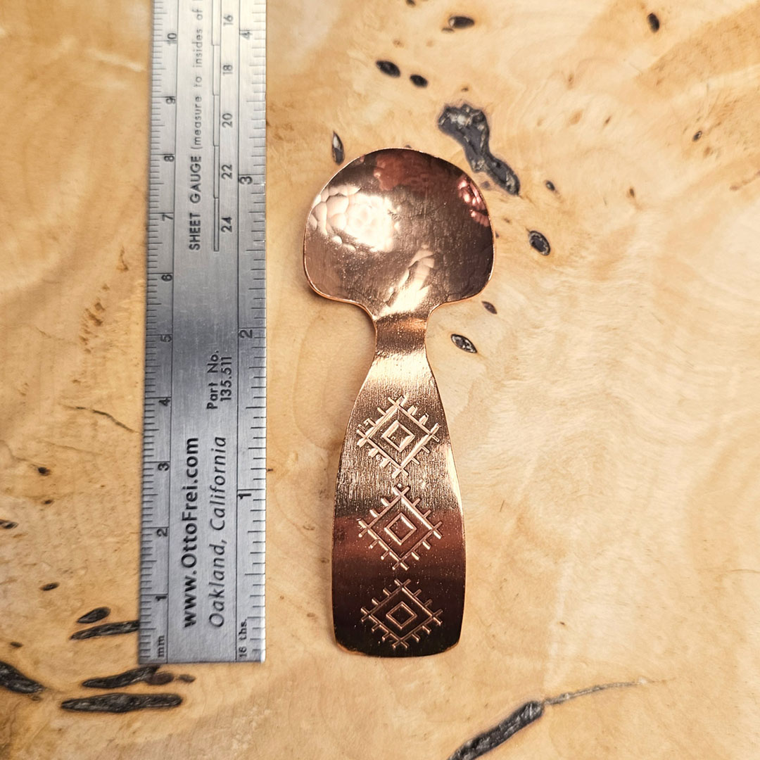 A small condiment spoon on a wood surface.