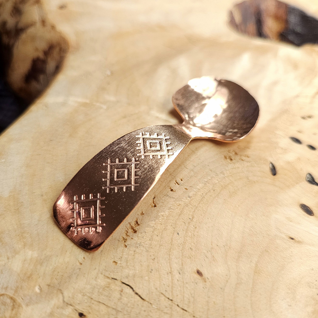 A small condiment spoon on a wood surface.