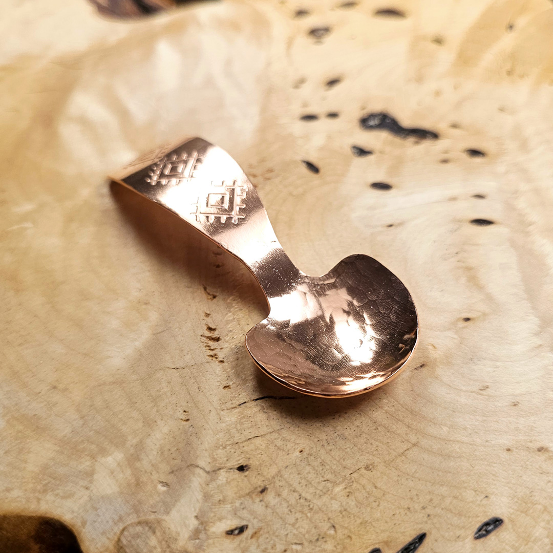 A small condiment spoon on a wood surface.