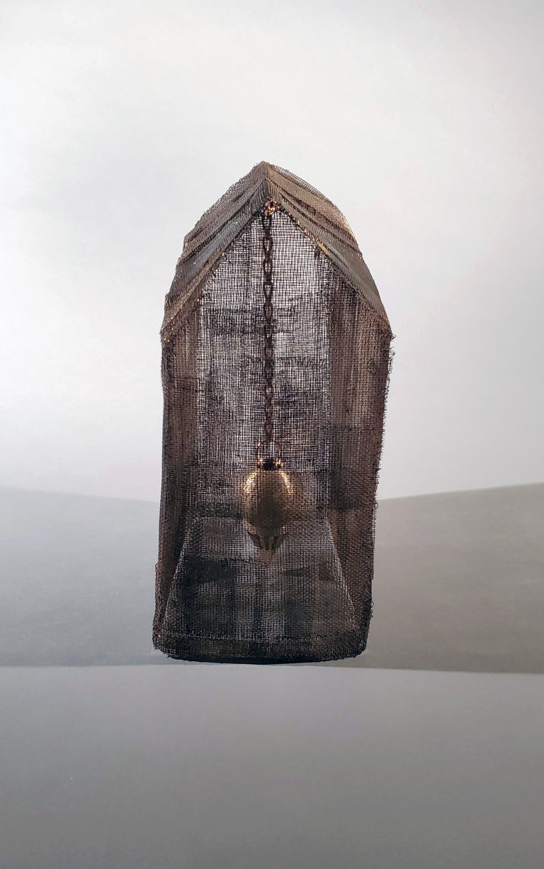 A straight-on view of the screen house with a cast bronze plumb bob visible inside.