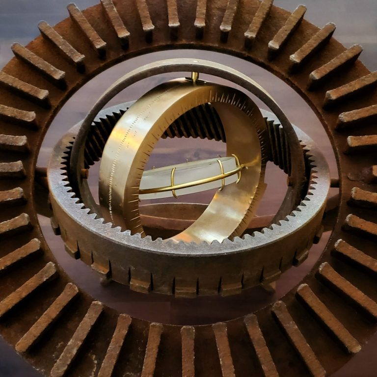 A view of the sculpture showing rusty rings, the bronze bezel, and the lens