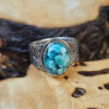 A stamped Hubei turquoise ring on a wood surface