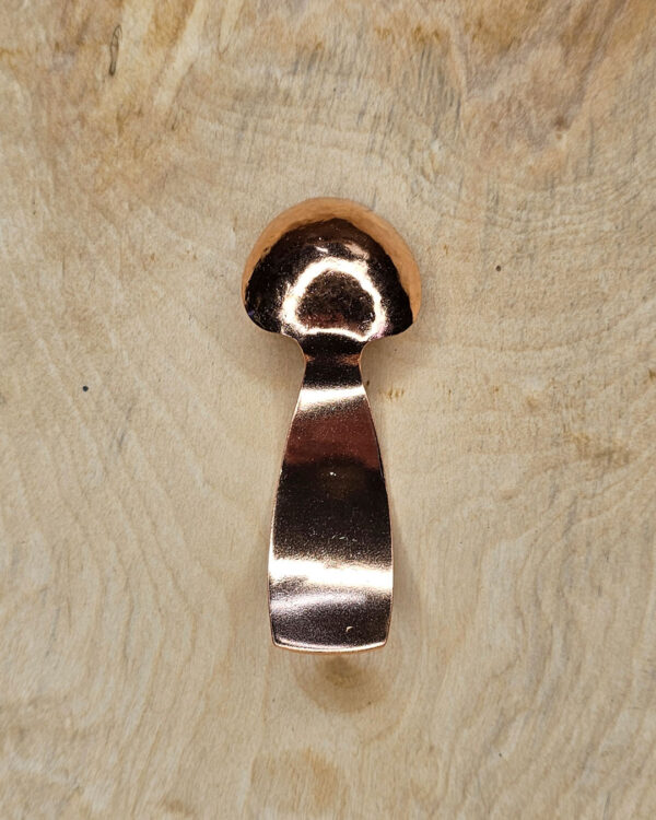 A small copper spoon stamped with three traditional eight-pointed stars