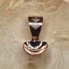 A small copper spoon stamped with three traditional eight-pointed stars