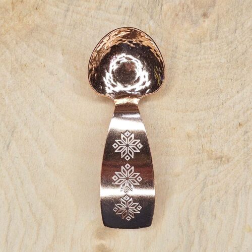 A small copper spoon stamped with three traditional eight-pointed stars