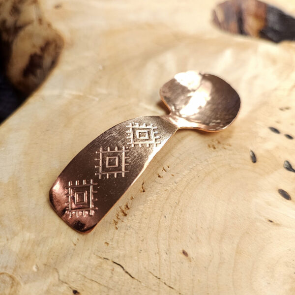 A small condiment spoon on a wood surface.