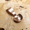 A small condiment spoon on a wood surface.