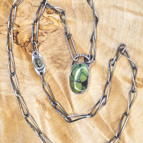 The handmade chain and green turquoise cabochon set in silver. Nearby on the chain is the smaller rultilated prehenite.
