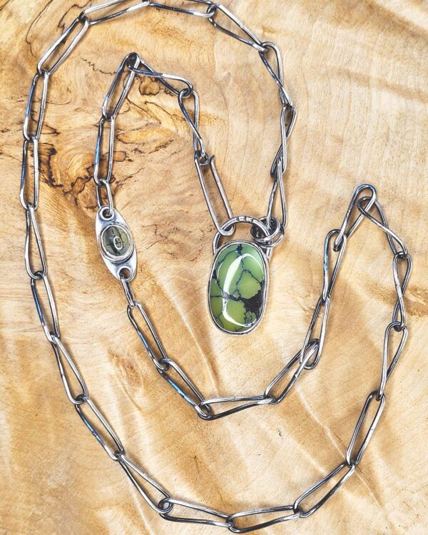The handmade chain and green turquoise cabochon set in silver. Nearby on the chain is the smaller rultilated prehenite.