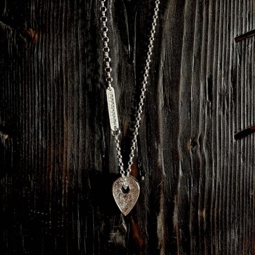 A necklace featuring a map marker planchette pendant made with reticulated silver and framed in a narrow sterling silver strip