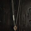 A necklace featuring a map marker planchette pendant made with reticulated silver and framed in a narrow sterling silver strip