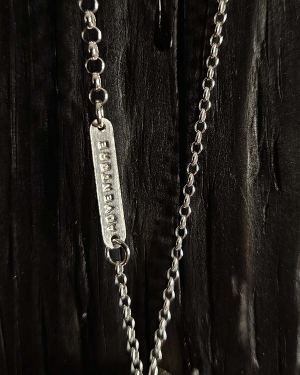A necklace featuring a map marker planchette pendant made with reticulated silver and framed in a narrow sterling silver strip