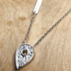 A necklace featuring a map marker planchette pendant made with reticulated silver and framed in a narrow sterling silver strip