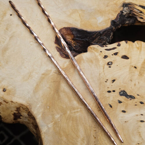 The Twisted Copper Chopsticks on a wood background