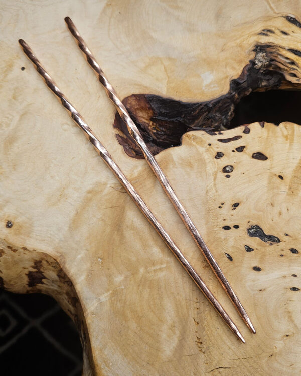 The Twisted Copper Chopsticks on a wood background