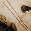 Narrow cooper chopsticks on a wood surface