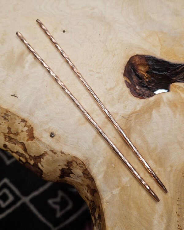 Narrow cooper chopsticks on a wood surface