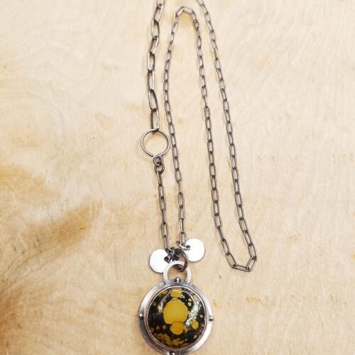 YellowTurquoiseNecklace-Full A pendant set with a yellow turquoise on a sterling silver chain sits on a wood background