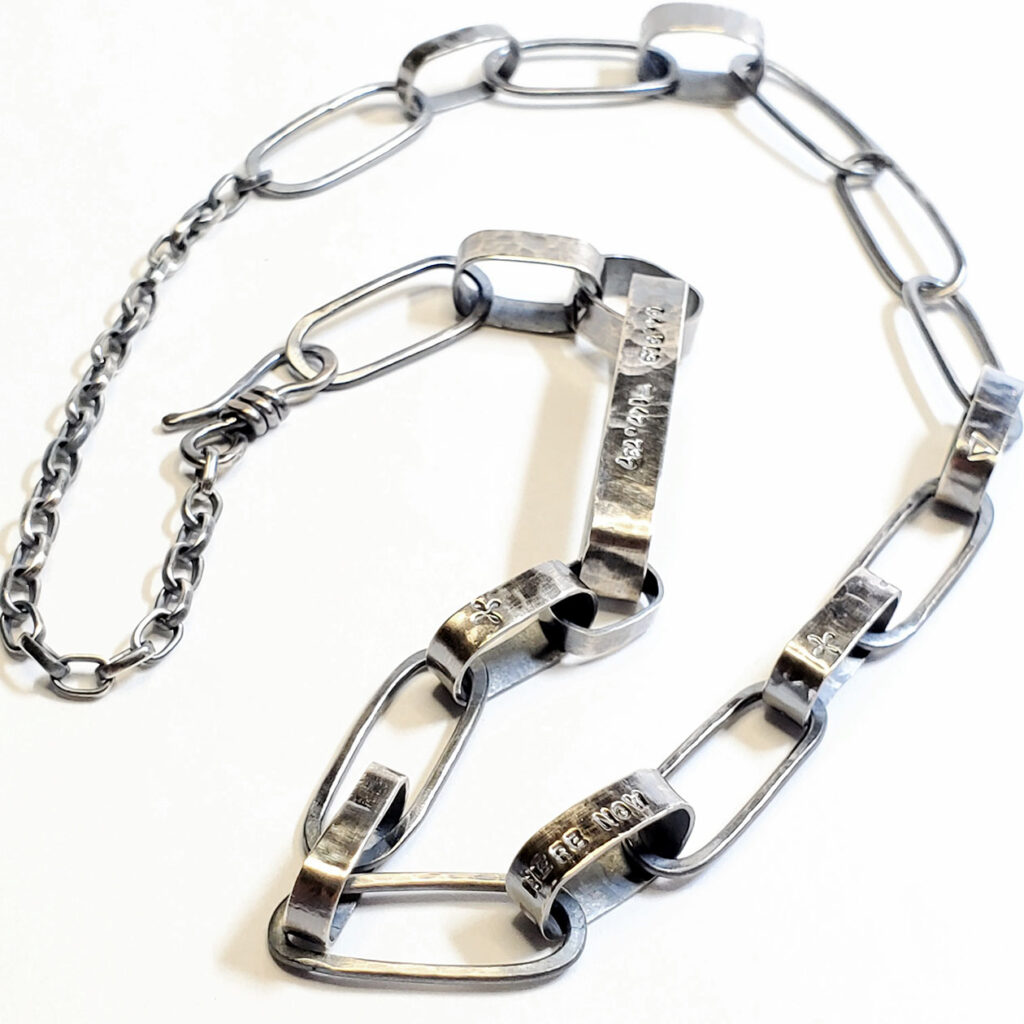 A view of the Sanctuary necklace arranged on a flat white surface